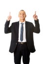 Businessman pointing upwards and smiling at camera Royalty Free Stock Photo