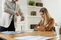 Businessman pointing on wrist watch while scolding employee for being late Royalty Free Stock Photo