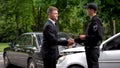 Businessman and policeman shaking hands car accident scene, collision settlement Royalty Free Stock Photo