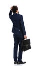 Businessman pondering something and holding a briefcase Royalty Free Stock Photo