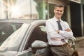 Businessman posing with his car