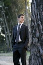 Businessman posing relaxed on a park forest