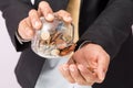 Businessman pouring coins fromn the glass to his hand, concept of saving  money for finance accounting, growing business Royalty Free Stock Photo