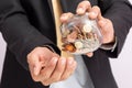 Businessman pouring coins fromn the glass to his hand, concept of saving  money for finance accounting, growing business Royalty Free Stock Photo