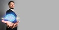 Businessman presenting an AI icon of a shining blue brain emitting energy and power Royalty Free Stock Photo