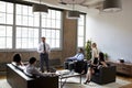 Businessman presenting at an informal meeting, wide shot Royalty Free Stock Photo