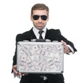 Businessman presenting metal suitcase full of money.