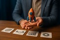Businessman presenting orange clay rocket over goal, partnership, growth and process icons symbolizing business startup, Royalty Free Stock Photo