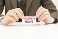 businessman presenting & x27;PRIORITY RIGHT& x27; word on white card Royalty Free Stock Photo