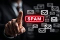 Businessman is pressing a red spam button with email icons in the background Royalty Free Stock Photo