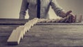 Businessman preventing dominoes from crumbling with palm