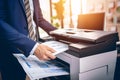 Businessman print paper on a multifunction laser printer in business office. Document and paperwork. Secretary work. Copy, print,