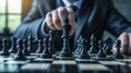 Strategic businessman in suit moving chess figure on chessboard