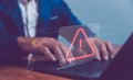 Businessman or programmer using laptop with triangle caution warning sign, coding, cryptography, hacker, crime, virus, for Royalty Free Stock Photo