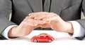 Businessman protect with his hands a red car, concept for insurance, buying, renting, fuel or service and repair costs Royalty Free Stock Photo