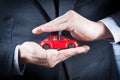 Businessman protect with his hands a red car, concept for insurance, buying, renting, fuel or service and repair costs Royalty Free Stock Photo