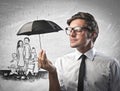 Businessman protecting a family from the rain