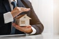 Businessman protecting house model with hands. Real estate and property Insurance concept Royalty Free Stock Photo