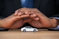 Businessman protecting toy car with hands Royalty Free Stock Photo