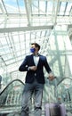 Businessman in protective mask at the airport going down the escalator