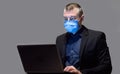 Businessman In Protective Mask Working On Laptop Over Gray Background