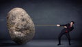 Businessman pulling huge rock with a rope