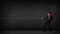 Businessman pulling rope on grey background Royalty Free Stock Photo