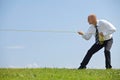 Businessman pulling rope in park Royalty Free Stock Photo