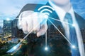 Businessman push wifi icon on city and network connection concept. Bangkok smart city and wireless communication network, abstract Royalty Free Stock Photo