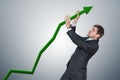 Businessman is pushing arrow in graph up. Growth and maximizing earnings concept