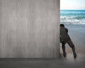 Businessman pushing gray concrete wall away