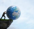 Businessman pushing planet Earth off a cliff Royalty Free Stock Photo
