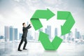 Businessman pushing recycling symbol