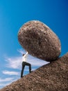 Businessman pushing up boulder