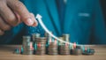 Businessman puts money on pile of coins. Ideas for investing and growing a business, maximizing profits from business, ideas for