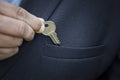 businessman puts a small key to a safe deposit box or a bank in his jacket pocket the concept of saving money. The real Royalty Free Stock Photo