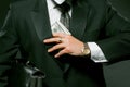 Businessman puts wad of banknote in his pocket holding black briefcase under his arm. Caucasian man wearing black suit Royalty Free Stock Photo