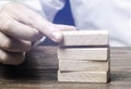 Businessman puts wooden blocks. Business management concept. Planning and strategy. Setting and achieving goals. Business