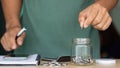 Businessman putting coins in a glass jar with a calculator and notebook. the concept of saving money for the future, Business, Royalty Free Stock Photo