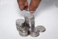 A businessman putting coins over a stack of coins. Financial, economy, investment and savings concept. Banking and exchange object