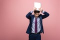 Businessman quarreling while holding laptop above head on pink background