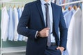 Businessman and rack with clean clothes at dry-cleaner`s