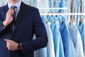 Businessman and rack with clean clothes at dry-cleaner`s. Space for text