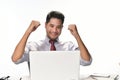 Businessman raising his hand feeling happy for achieving work while using laptop computer
