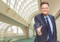 Businessman Reaching for Hand Shake Inside Corporate Building