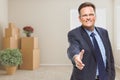 Businessman Reaching for Hand Shake in Room with Packed Boxes Royalty Free Stock Photo