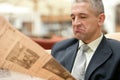 Businessman reading bad news on a business newspaper