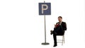 Businessman reading a book near parking sign on white background isolated Royalty Free Stock Photo