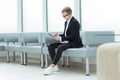 Businessman reading a business document sitting in the office lobby Royalty Free Stock Photo