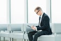 Businessman reading a business document sitting in the office lobby Royalty Free Stock Photo